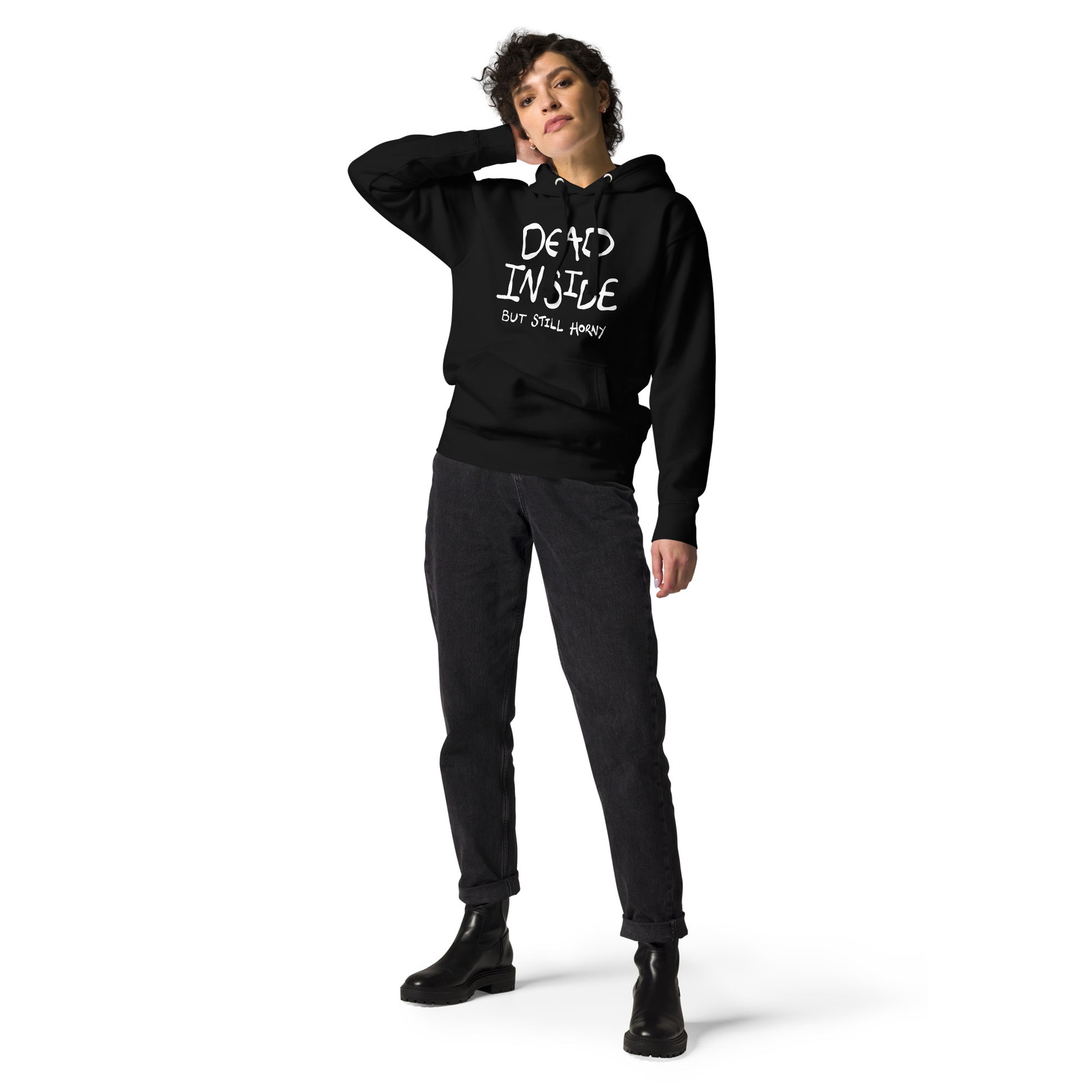 Person wearing a black hoodie with text DEAD INSIDE BUT STILL HORNY, standing against a white background