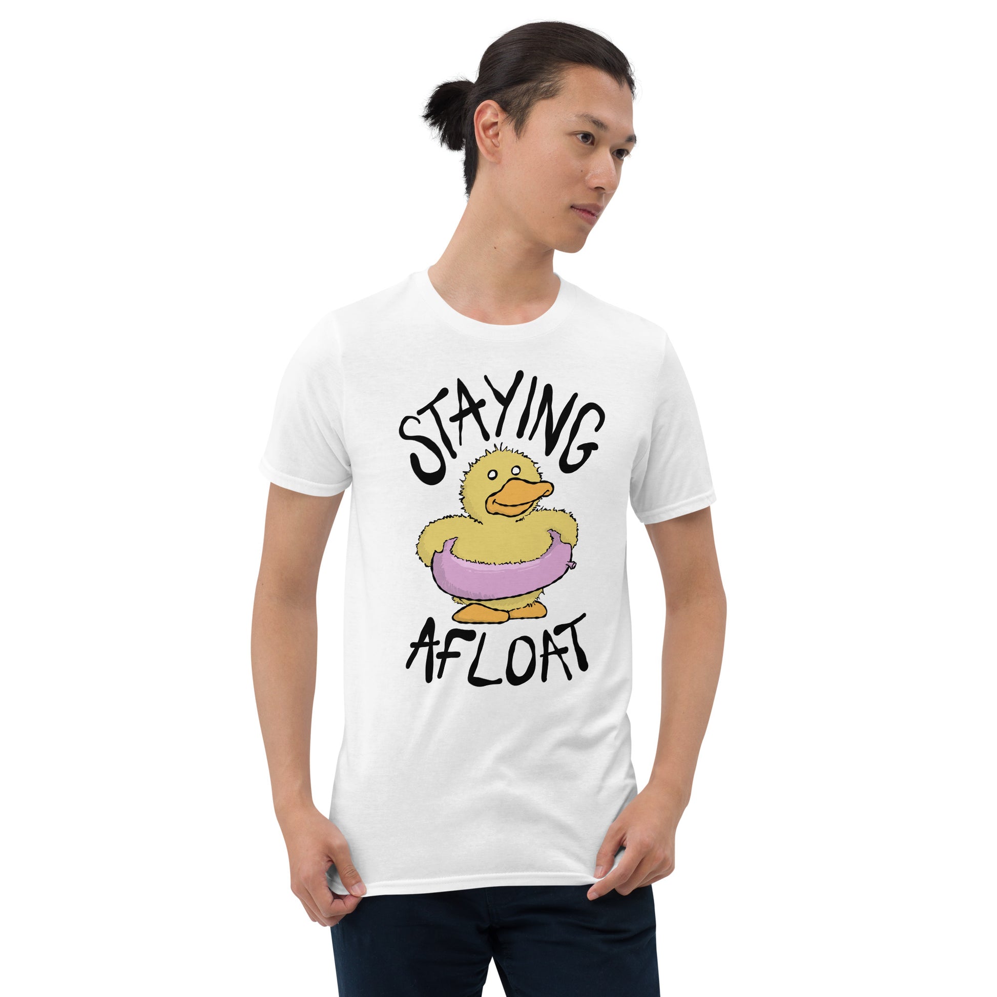 Man wearing a white t-shirt with a graphic of a duck and text 'STAYING AFLOAT' on a white background